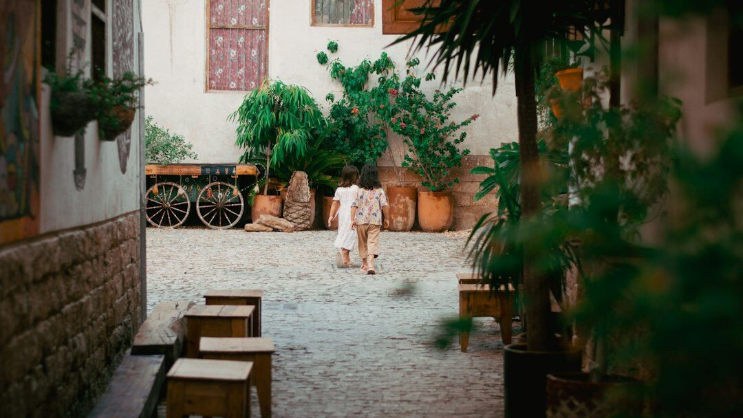 Documentary photographer crouching to photograph children playing in a Danish housing courtyard
